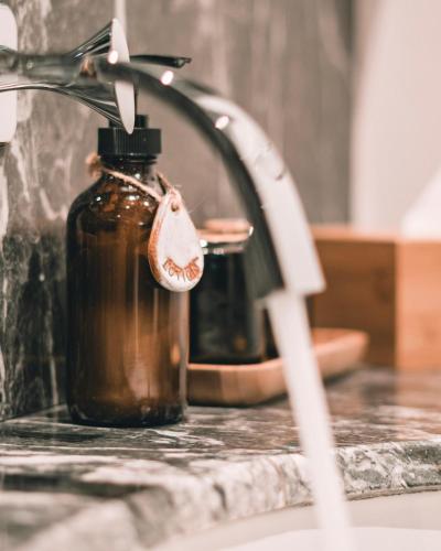 a bottle of oil sitting next to a kitchen faucet at Hotel Vellita Siem reap in Siem Reap