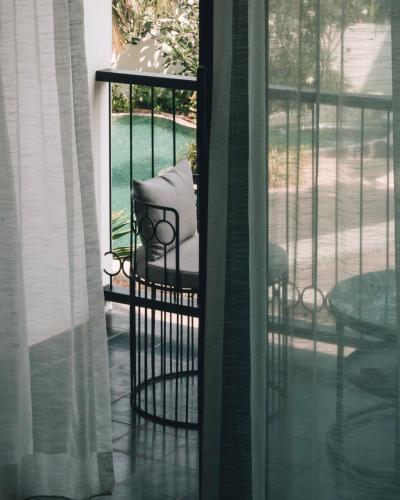 a chair on a porch with a view of a yard at Hotel Vellita Siem reap in Siem Reap