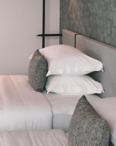 a bed with four pillows on it at Hotel Vellita Siem reap in Siem Reap