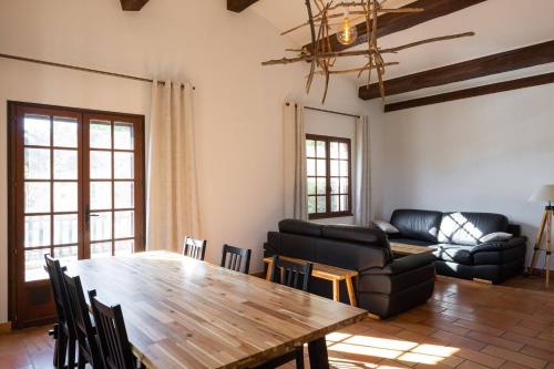 sala de estar con mesa de madera y sofá en Mas Provençal de 120m2 en Camargue, Avec Piscine et Parking inclus, Idéal pour des vacances, en Arles