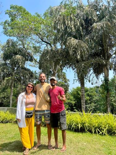 three people posing for a picture in front of a tree at Green Hill Paradise Villa in Unawatuna