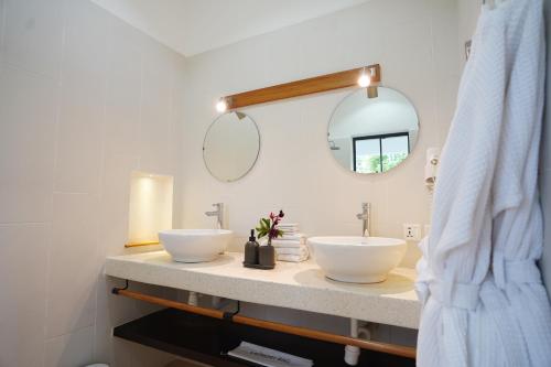 La salle de bains est pourvue de 2 lavabos et d'un miroir. dans l'établissement Kili Seasons Hotel, à Arusha