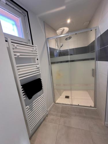La salle de bains est pourvue d'une douche à l'italienne et d'une cabine de douche en verre. dans l'établissement Envies D’Ailleurs Centre Ville, à Saint-Brévin-les-Pins