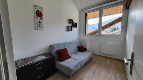 a living room with a couch and a window at 'Games of Home' - logement T3 in Saint-Égrève