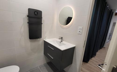 La salle de bains est pourvue d'un lavabo et d'un miroir. dans l'établissement 'Games of Home' - logement T3, à Saint-Égrève