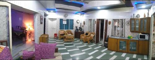 una sala de estar con sillas y una planta de tablero de ajedrez en Mayur Villa, en Agra