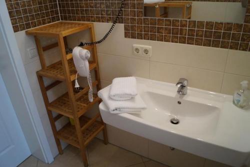 a bathroom with a sink and a towel rack at Villa Strandkuss in Kühlungsborn