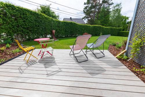a group of chairs and a table on a deck at Tiny house avec vue sur les étoiles in Jalhay