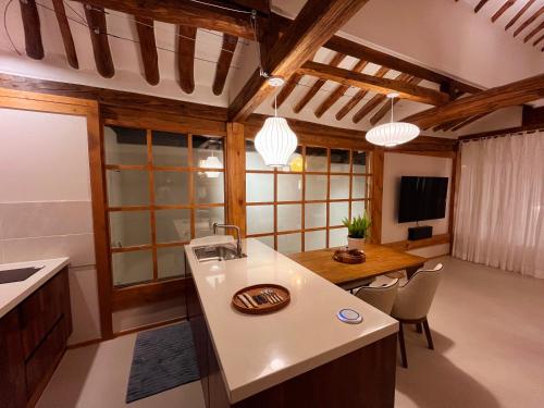 a kitchen with a sink and a table with chairs at Dalbbit hyang in Jeonju