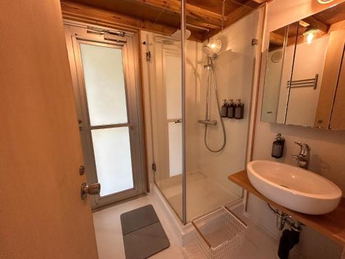 a bathroom with a shower and a sink at SHINMINKA Villa UTTABARU - Vacation STAY 92209 in Amami