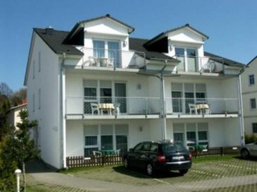 a black car parked in front of a white house at Appartementhaus Anne in Binz