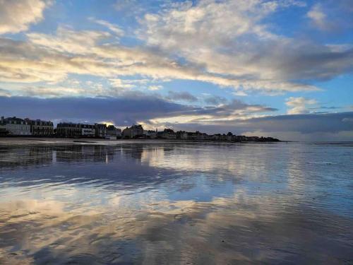 a body of water with a cloudy sky at L'Horizon - Duplex face à la Mer tout confort in Saint-Aubin-sur-Mer