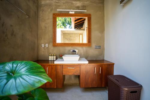 un bagno con lavandino e specchio di Omkara Rekawa a Tangalle