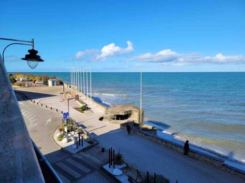 a view of the ocean from a pier at L'Horizon - Duplex face à la Mer tout confort in Saint-Aubin-sur-Mer