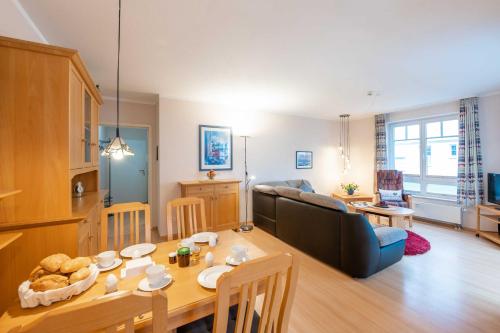 eine Küche und ein Wohnzimmer mit einem Tisch und einem Sofa in der Unterkunft Haus Seydlitz FV 13 in Binz