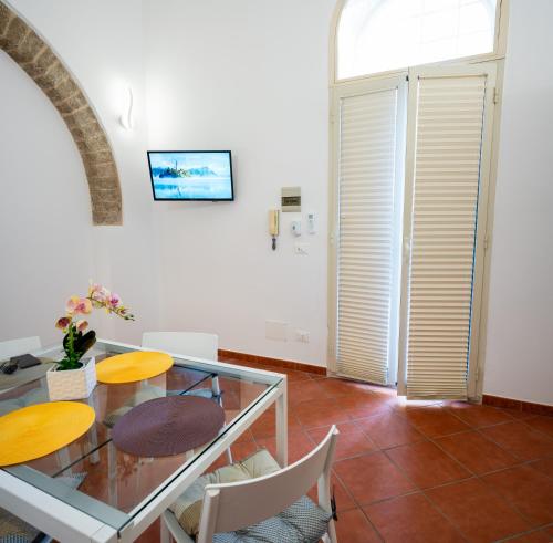 une salle à manger avec une table et des chaises en verre dans l'établissement Casa ORCHIDEA D'ORO, à Syracuse