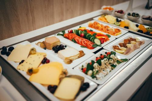 a tray filled with different types of cheese and vegetables at Landidyll Hotel Restaurant Weidenbrück & SPA in Swisttal