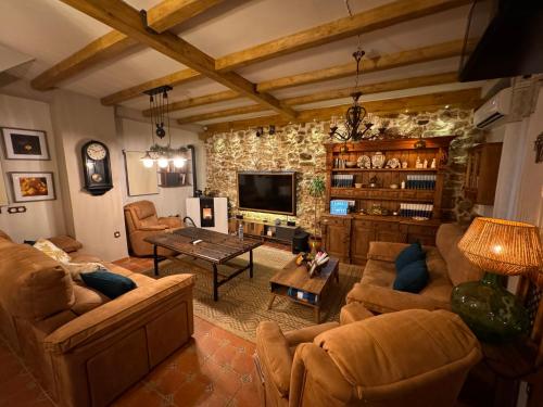 uma sala de estar com sofás e uma televisão em Cortijo Rodeo. Alojamiento Rural em Carcabuey
