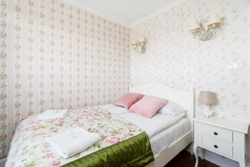 a bedroom with a bed with pink and green sheets at Malta Lake Apartment Balcony and Parking by Renters Prestige in Poznań