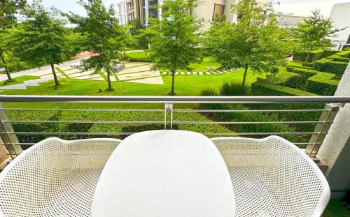 a balcony with two chairs and a view of a park at Menlyn Maine Residences - Kyoto king size xl bed in Pretoria