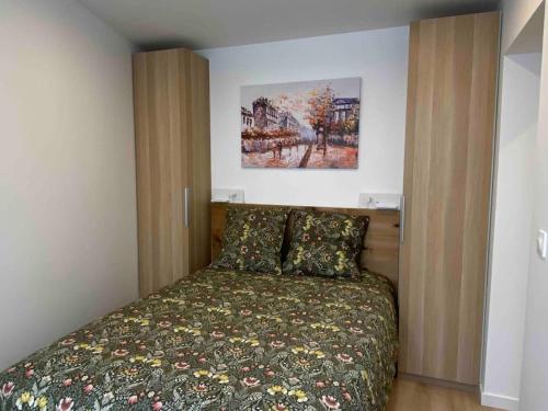 une chambre avec un lit et un tableau au mur dans l'établissement 23m2 climatisé avec Parking privé secteur Roosevelt - Arena, à Reims