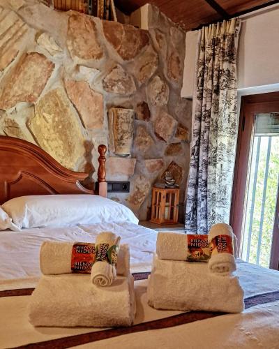 a bedroom with a bed with towels on it at Cortijo Rodeo. Alojamiento Rural in Carcabuey