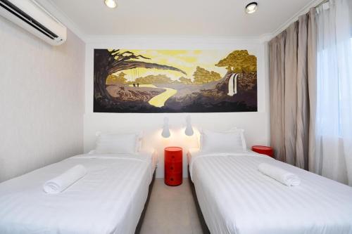 2 Betten in einem Zimmer mit Wandgemälde in der Unterkunft Smile Hotel Shah Alam ICity in Shah Alam
