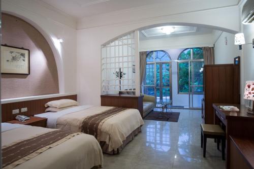 een hotelkamer met 2 bedden en een bureau bij Rainbow Resort Hotel in Wenquan