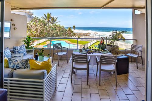 a patio with a table and chairs and a view of the ocean at Sands Beach Breaks Luxury Beach Front Ballito in Ballito