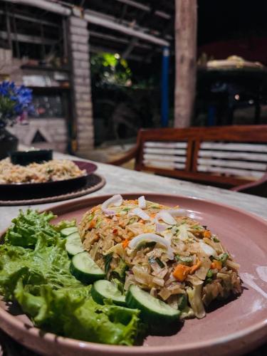a plate of food with a salad on a table at Moksha eco villa Ella in Ella