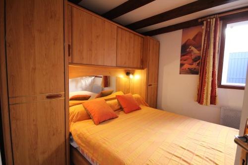 une chambre avec un grand lit avec des oreillers orange dans l'établissement Villa 6 couchages 3 chambres terrasse ombragée parking dans résidence sécurisée piscine commune 400m de la mer LRJP93, à Portiragnes