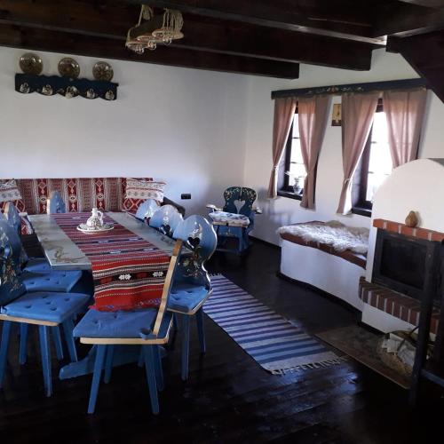 a living room with a table and chairs and a bed at Casuta Bunicii, Bran in Bran
