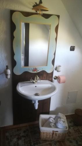 a bathroom with a sink and a mirror at Casuta Bunicii, Bran in Bran