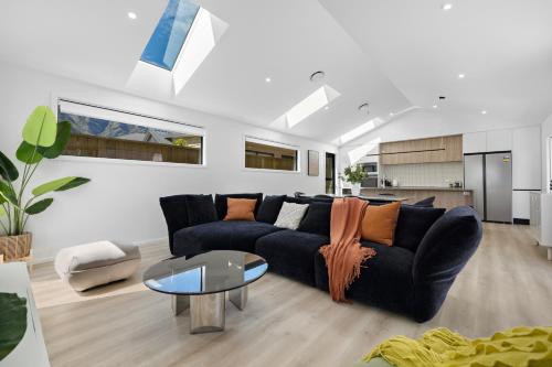 a living room with a black couch and a table at Luxury Away - Remarkable Retreat in Frankton Wharf