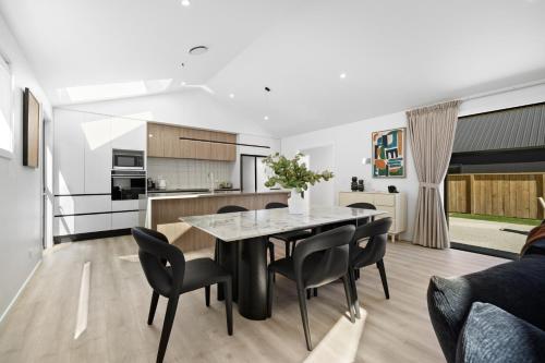 a kitchen and dining room with a table and chairs at Luxury Away - Remarkable Retreat in Frankton Wharf