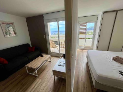 een kamer met een bed, een bank en een tafel bij Bel appartement vue mer - Mafat'appart in La Possession