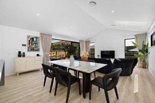 a dining room and living room with a table and chairs at Luxury Away - Remarkable Retreat in Frankton Wharf