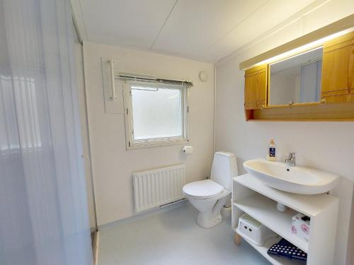 ein Bad mit einem WC und einem Waschbecken in der Unterkunft Woody in Brösarp