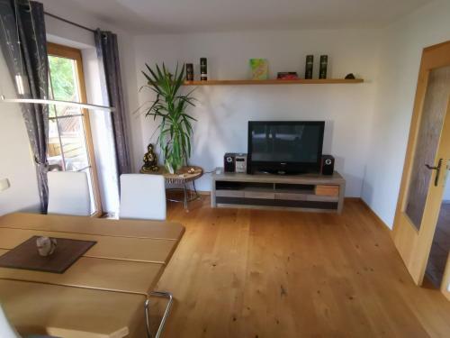 a living room with a flat screen tv and a table at Im Ruhepol in Petting