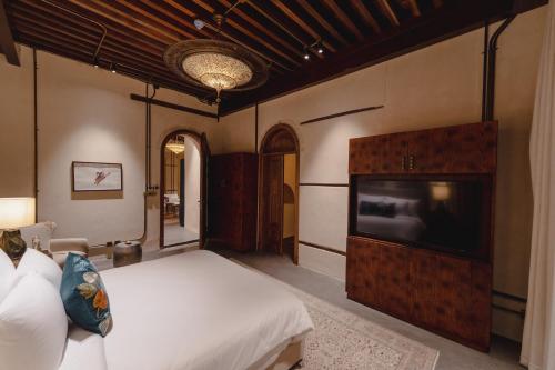 a bedroom with a bed and a flat screen tv at Al Balad Hospitality in Jeddah