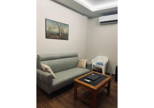 a living room with a couch and a table at Sunset Homes Imphal in Imphal