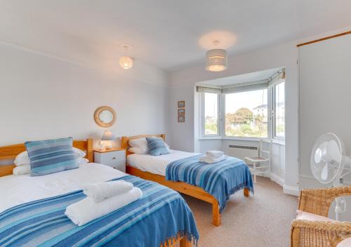 a bedroom with two beds and a window at Marnies View in Sidmouth