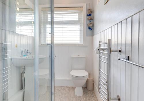uma casa de banho branca com um WC e um lavatório em Marnies View em Sidmouth