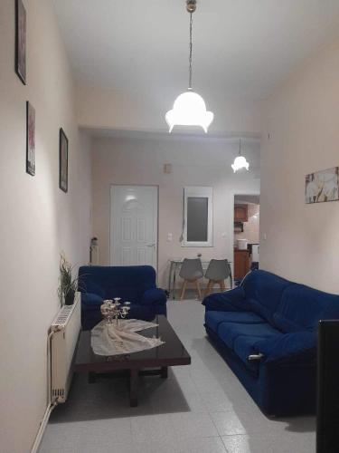 a living room with a blue couch and a tv at Apartment MCS in Igoumenitsa