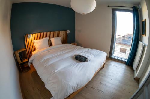 Un dormitorio con una cama con una cámara. en La Ruche des carrés - T3 vue panoramique, en Annecy