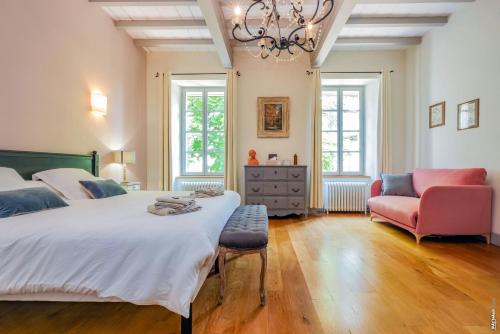 1 dormitorio con 1 cama grande y 1 silla en La Maison de Clément, en Lisle-sur-Tarn