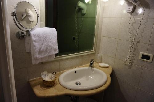 bagno con lavandino e specchio di Green Hotel a Roma