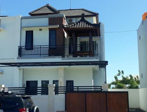Cette maison blanche dispose d'un balcon. dans l'établissement Chandra's guest house, à Pesanggaran