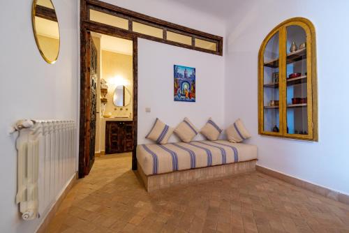 un soggiorno con divano e specchio di Riad Cologne & Spa a Marrakech
