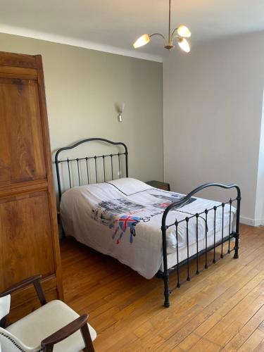 une chambre avec un lit et une chaise dedans dans l'établissement Location maison à Chadron : Haute Loire, à Chadron